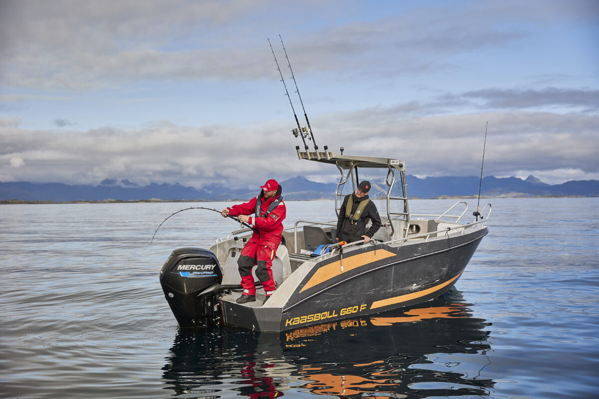 Man angelt vom Boot aus und hat einen großen Fisch am Haken